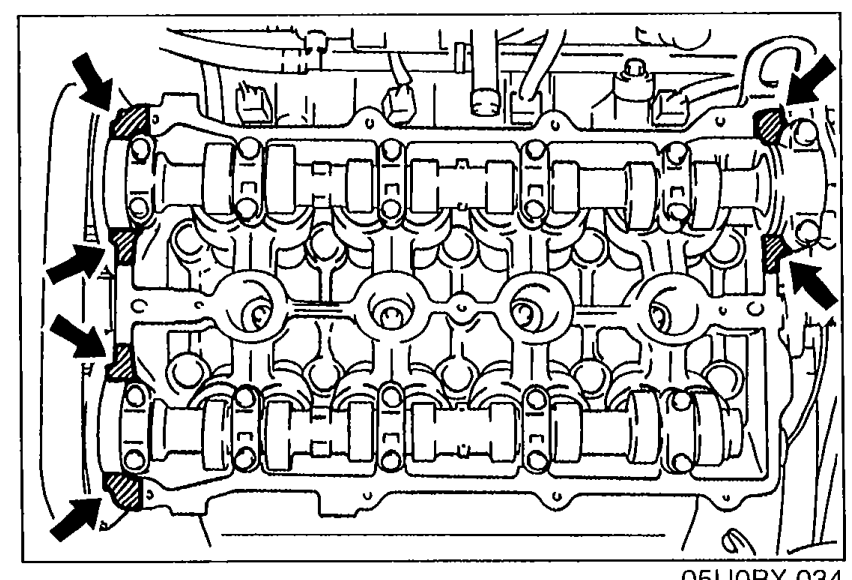 Top view of cylinder head cover with arrows indicating multiple locations along the perimeter where silicone sealant should be applied to shaded areas.