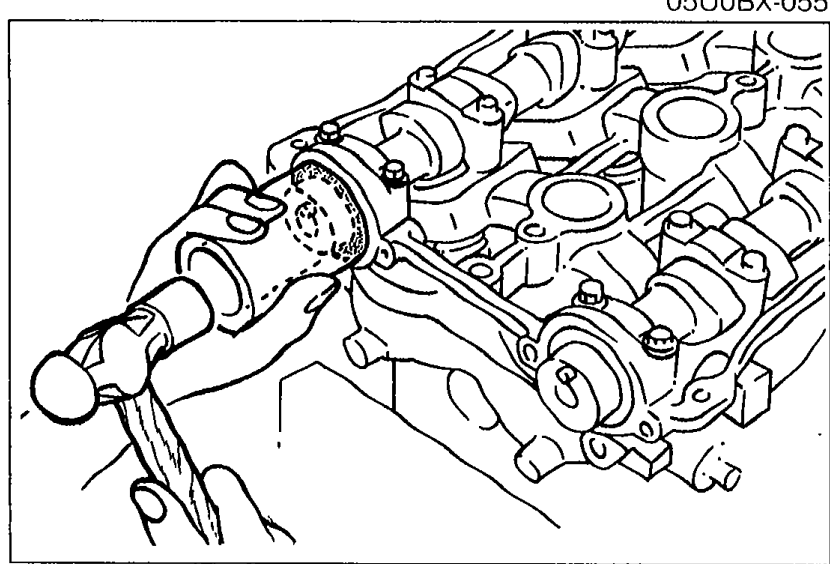 View of cylinder head end showing the camshaft oil seal being tapped into place with a suitable pipe and hammer.