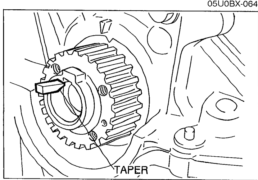 Installing the pulley Woodruff key with the tapered side toward the oil pump body. Arrow labeled TAPER points to the tapered side of the key.