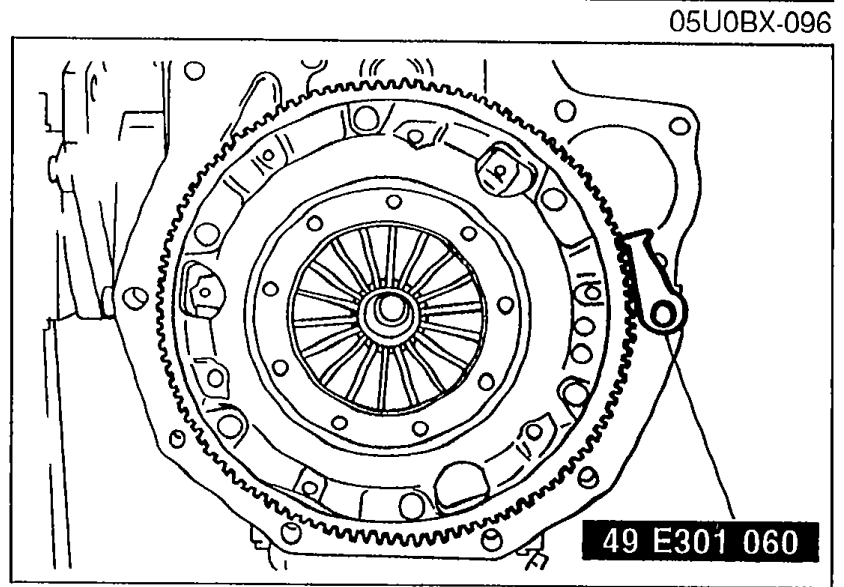 Flywheel held by SST 49 E301 060 ring gear brake while loosening the timing belt pulley lock bolt.