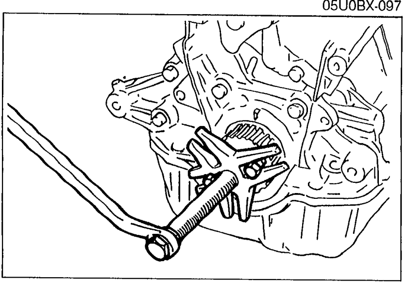 Steering wheel puller (commercially available) being used to remove the timing belt pulley from the crankshaft.