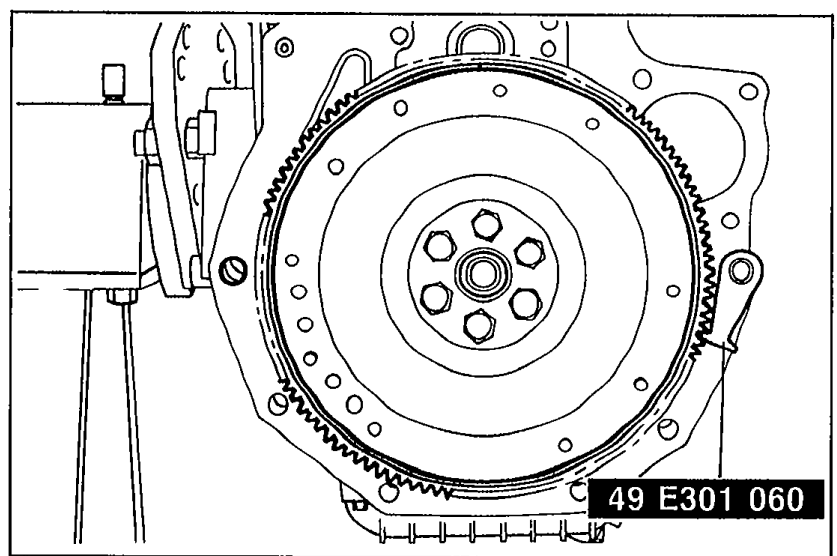 Flywheel held in place with SST 49 E301 060 engaged in the ring gear teeth to prevent rotation while removing the flywheel lock bolts.