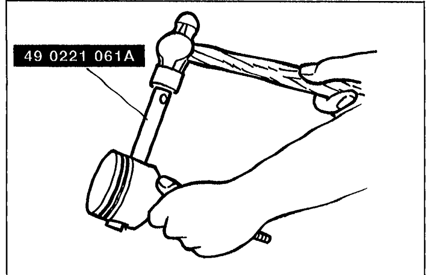 Removing the piston pin using SST 49 0221 061A clamped in a press, with the piston and connecting rod assembly being supported by a hand.