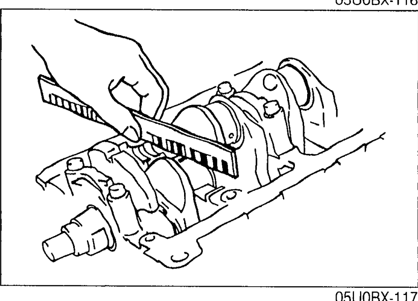 Measuring main bearing oil clearance with Plastigage strips placed on the main journals of the crankshaft inside the inverted cylinder block.