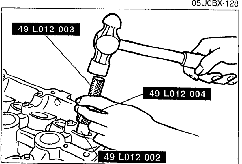 Driving the valve guide into the cylinder head from the spring-seat side using the assembled SST (49 L012 003 + 49 L012 004 + 49 L012 002) with a hammer until the SST contacts the cylinder head.