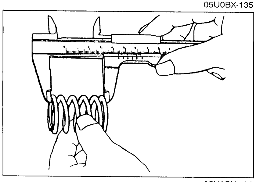 Measuring valve spring free length with a vernier caliper across the unloaded spring.
