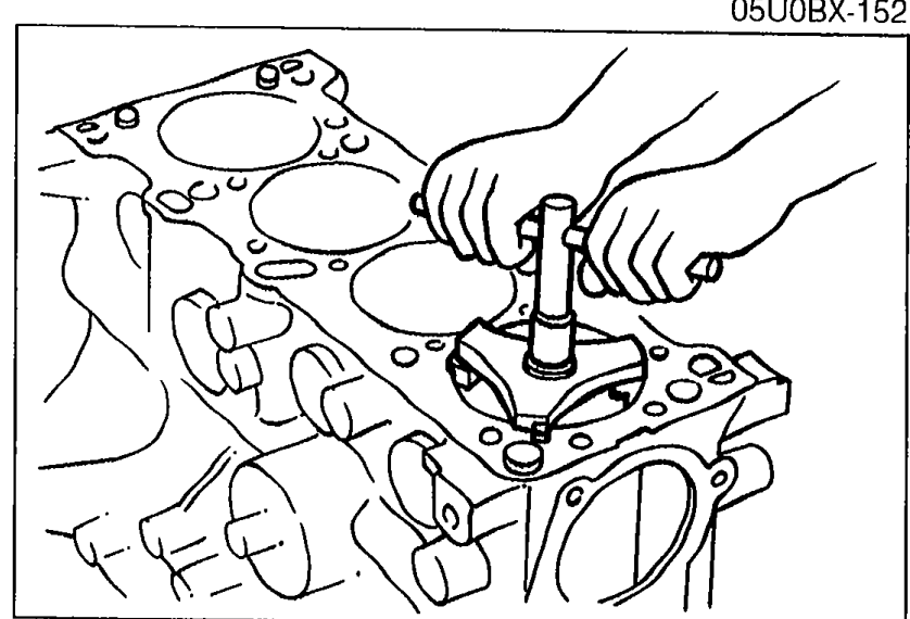 Hand using a ridge reamer tool inside the top of a cylinder bore to remove the ridge from the upper part of the cylinder wall.