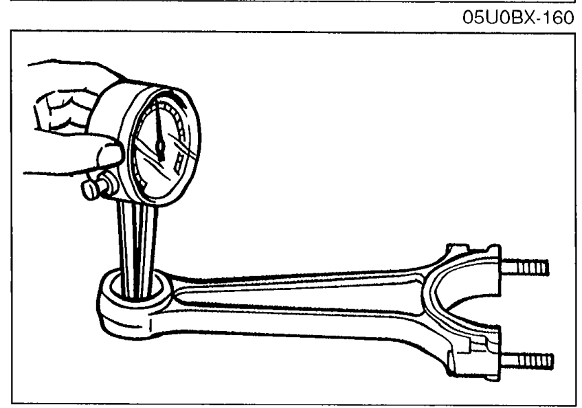 Dial indicator mounted on a connecting rod measuring the bushing inner diameter.