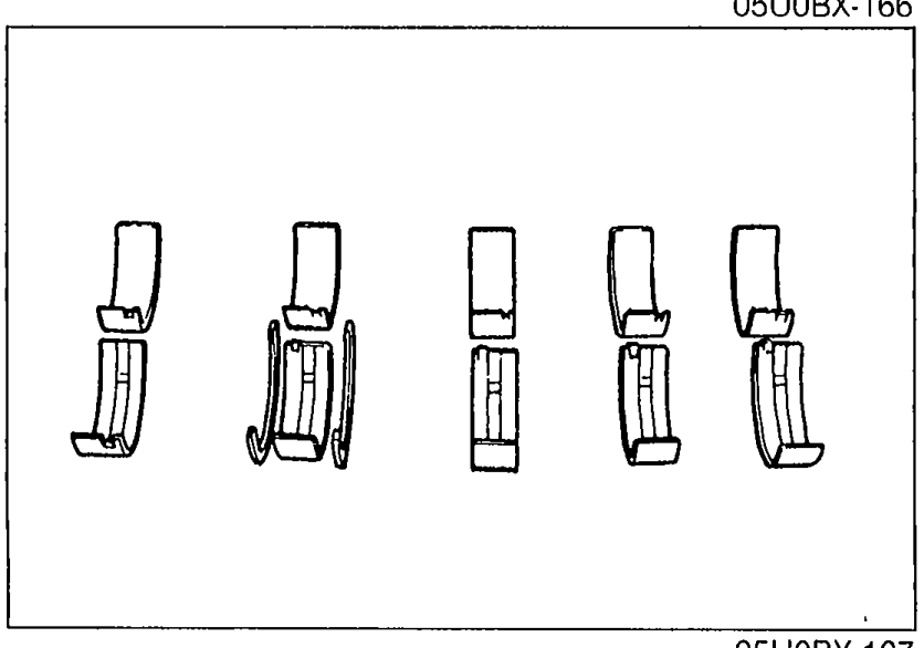 Four bearing shells laid out side by side (main bearings and connecting rod bearings) for inspection.