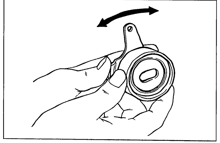 Hand holding the tensioner/idler pulley with an arrow indicating rotation to check for smooth turning.
