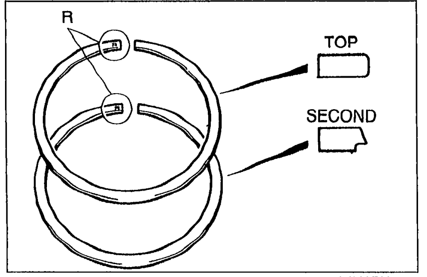 Top view of two piston rings showing 'R' identification marks. Labels: 'TOP' identifies the top ring and 'SECOND' identifies the second ring, each showing the orientation mark.