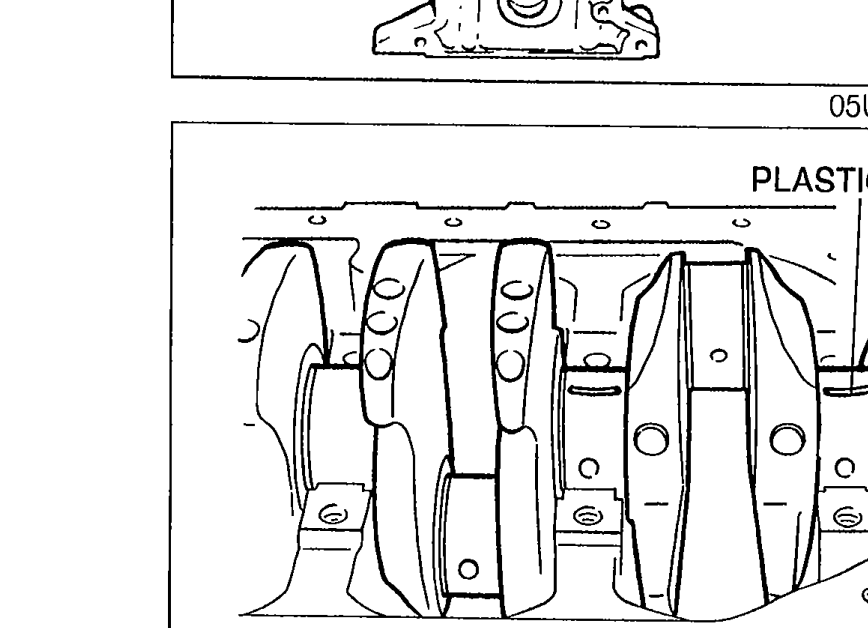 Crankshaft installed in the cylinder block with Plastigage strips positioned atop each main journal in the axial direction. Label 'PLASTIGAGE' points to the strip.