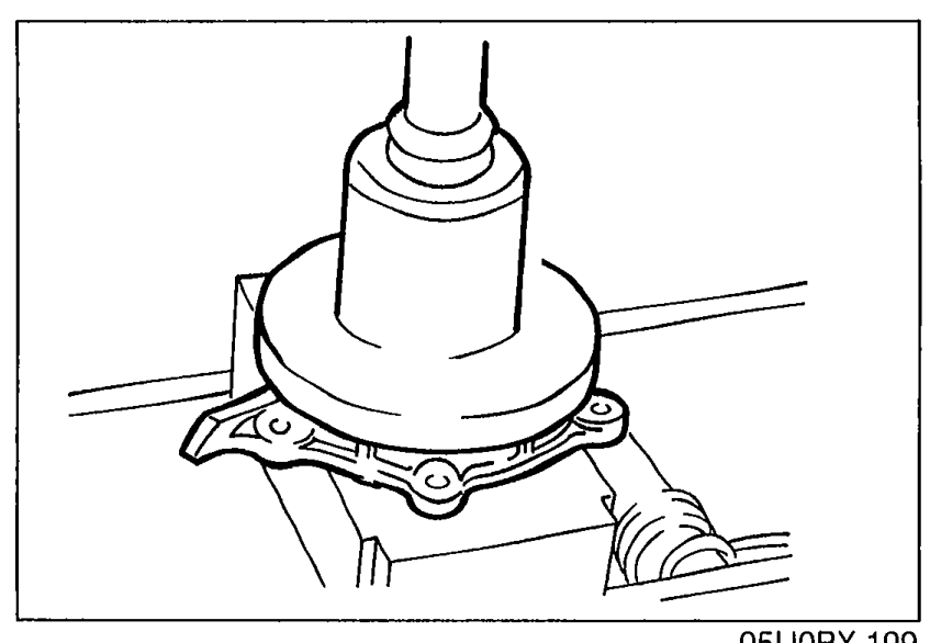 Pressing a new rear oil seal evenly into the rear cover using a suitable pipe-like driver tool, with the seal sitting on the cover surface.