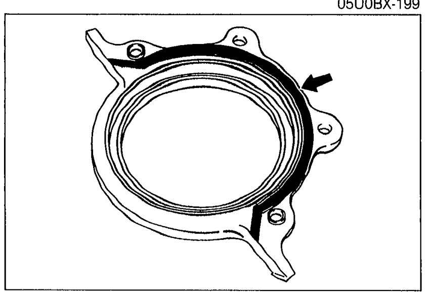 Rear cover viewed from the engine-facing side showing the oil seal area with an arrow indicating where silicone sealant should be applied to the shaded mating surface.