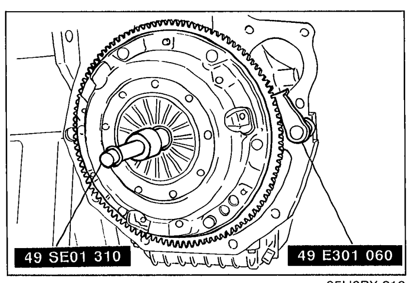 Clutch disc and clutch cover being installed on the flywheel using SSTs. Two SST callouts are visible: 49 SE01 310 (clutch alignment tool) and 49 E301 060 (flywheel holder).