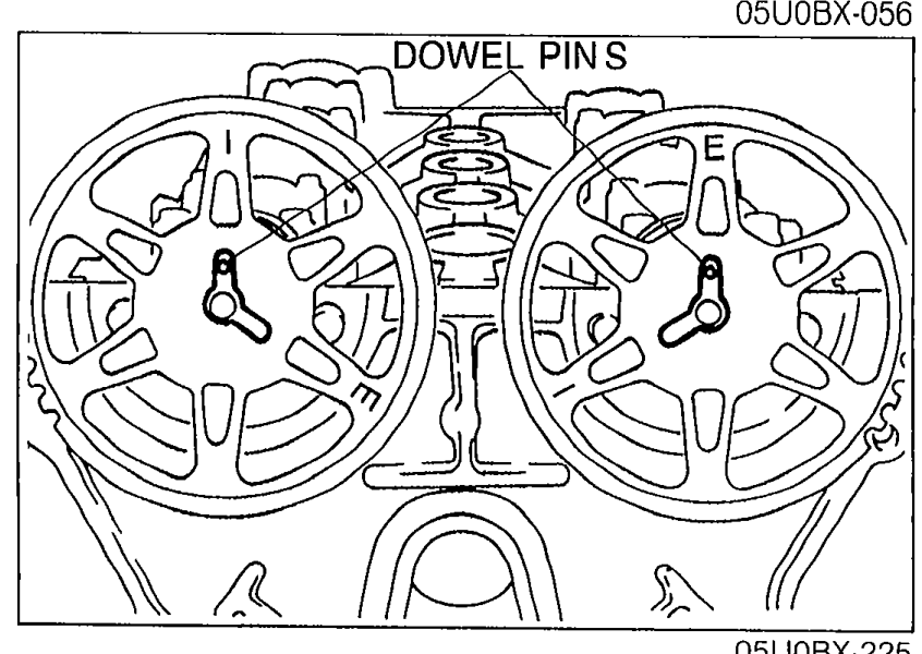 Camshaft pulleys with dowel pins facing straight up before installation. 'DOWEL PINS' callout points to the alignment pins.