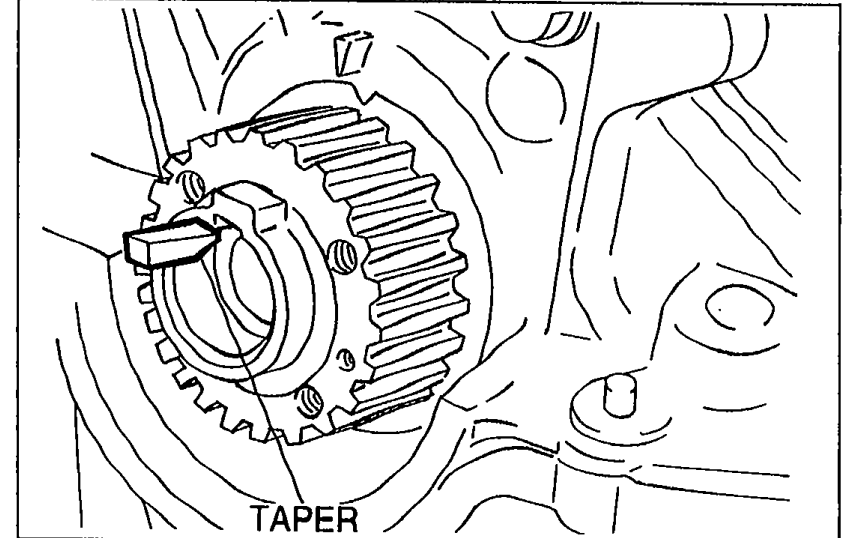 Timing belt pulley (camshaft pulley) with the Woodruff key visible. 'TAPER' label points to the tapered side of the Woodruff key, which should face the oil pump body.