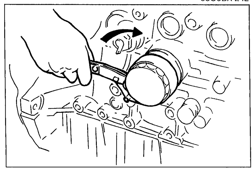 Hand installing the oil filter onto the engine block with a curved arrow showing the tightening rotation.