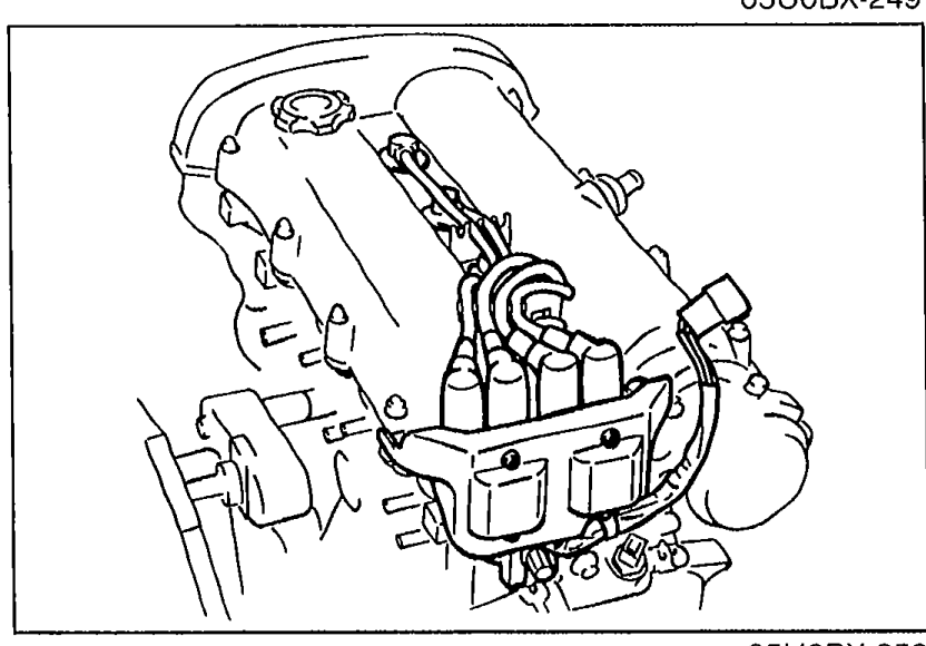 Ignition coil installed on the engine with the high-tension leads connected to the spark plug terminals.