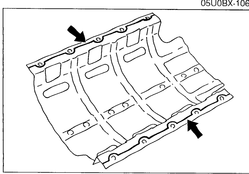 Photograph of the underside of the oil pan baffle with arrows indicating where a continuous bead of silicone sealant must be applied along the inside of the bolt holes.