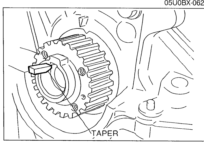 Photograph of the timing belt pulley with the Woodruff key installed, with a 'TAPER' label indicating the tapered side of the key.