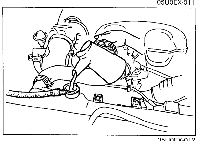 Engine bay photo showing draining or filling operation (radiator cap area).