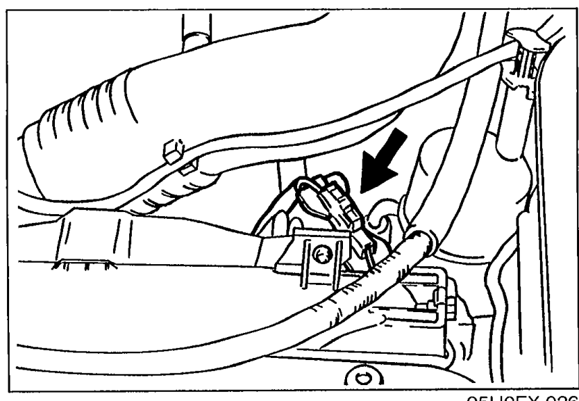 Engine bay view with an arrow pointing to the fan motor connector location for disconnection.
