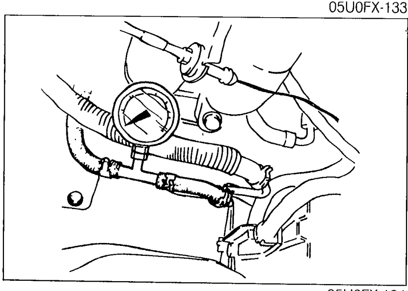 Fuel pressure gauge installed between the fuel pipe and the fuel main hose with hose clamps, as part of the fuel pressure hold inspection.