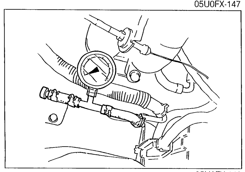Photo of a fuel pressure gauge connected to the fuel main pipe at the outlet, secured with clamps as shown in the procedure.