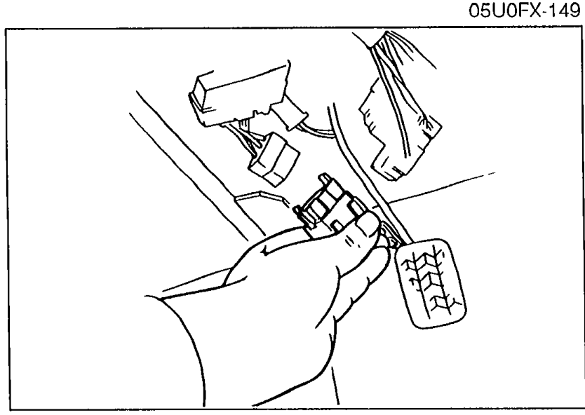 Photo of disconnecting the fuel pump electrical connector at the rear of the vehicle, to release fuel pressure before further work.