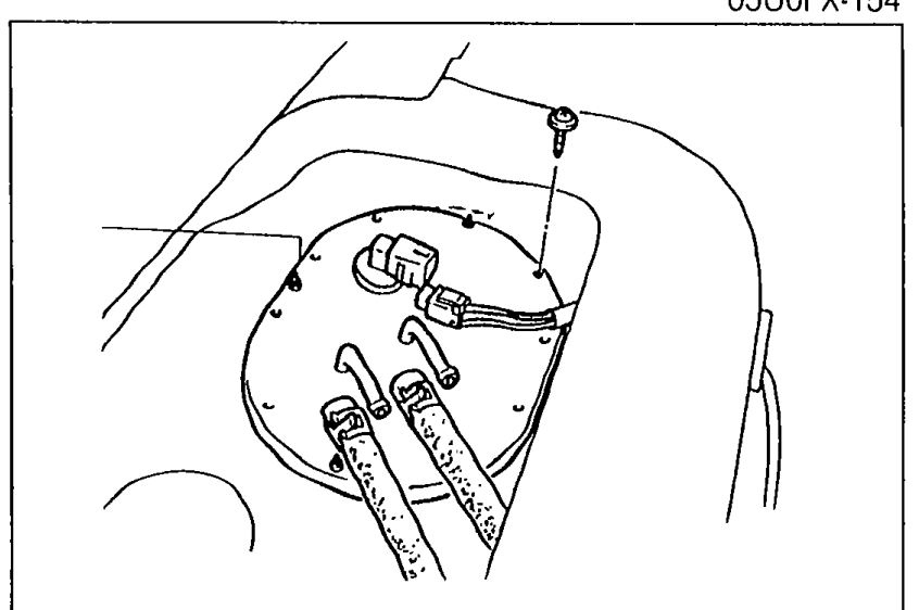 Photo of the fuel pump access opening with the fuel pump cover visible, showing the area to be exposed before removing the cover, connectors and hoses.