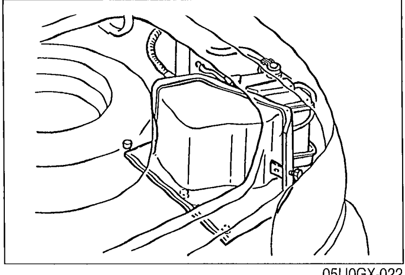 Engine bay view showing the battery cover installed over the new battery in its tray.