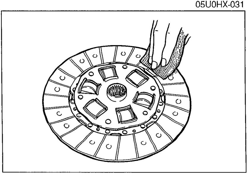 Clutch disc viewed from friction-surface side showing the lining, torsion-rubber/spring window, and rivets.