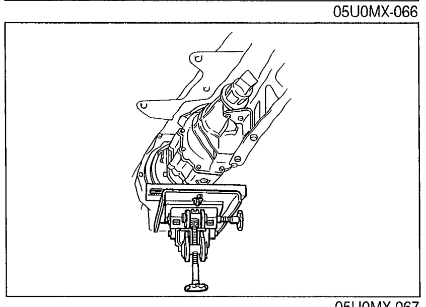 Photo of the power plant frame (PPF) area with the transmission supported by a jack and the wire harness routed along the PPF.