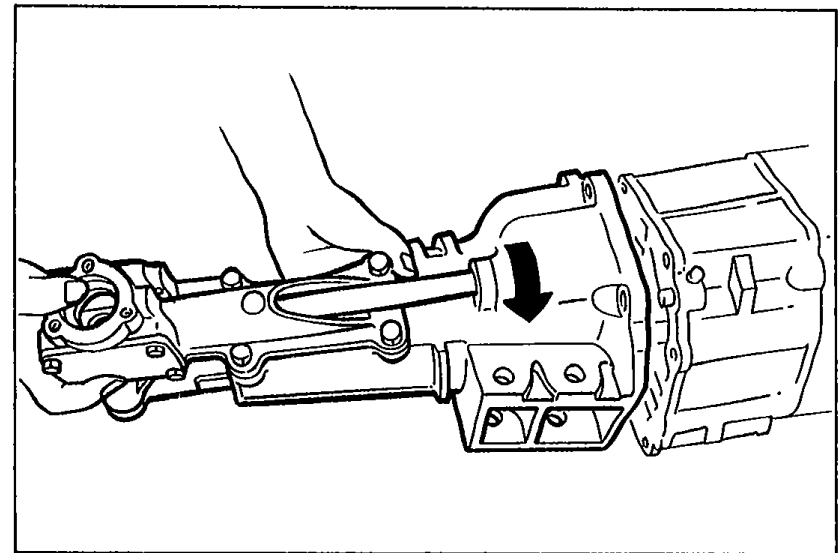 Illustration of the transmission with an arrow showing the rotational motion needed to turn the extension housing for removal.
