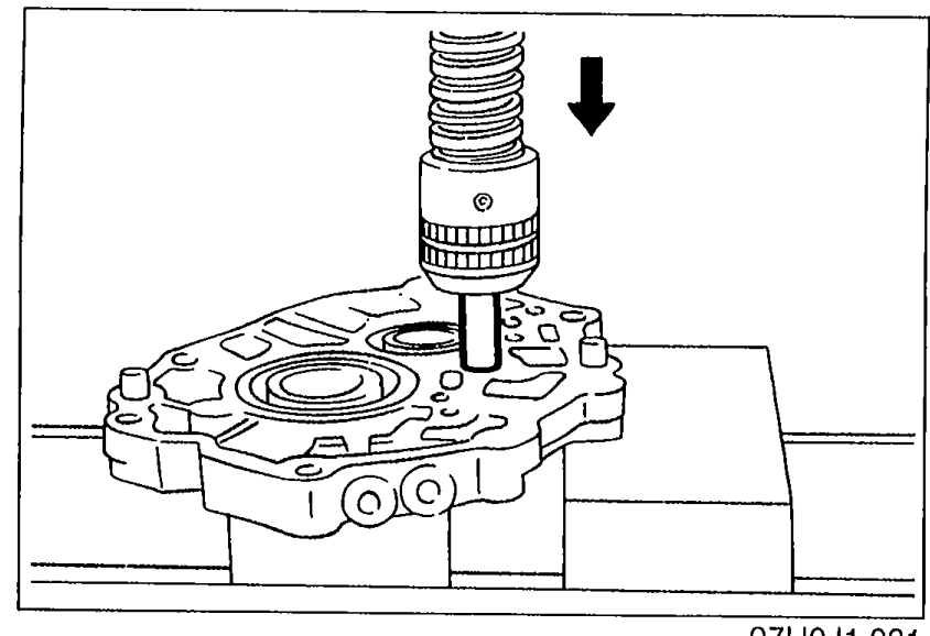Photograph showing a press ram pressing the reverse idler gear shaft downward out of the bearing housing. Downward arrow indicates press direction.