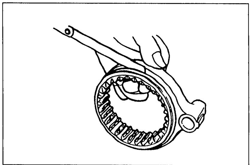 Hands using a feeler gauge to measure the clearance between the clutch hub sleeve and the shift fork.