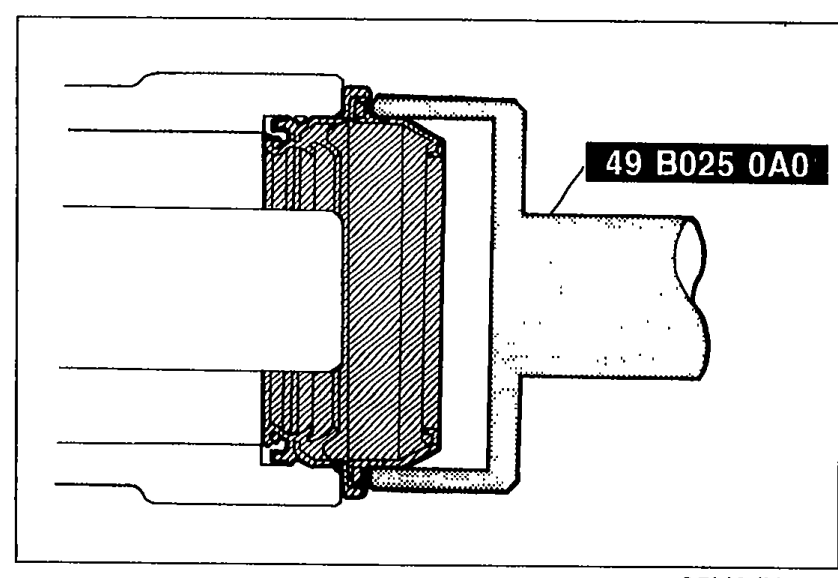 SST (part 49 B025 0A0) being used to install a new oil seal into the extension housing. Shows the cylindrical seal installer pressing into the seal area.