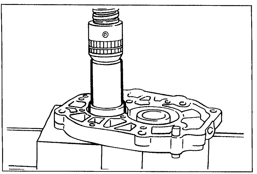 Illustration showing the countershaft center bearing being pressed into the bearing housing using a suitable pipe. The bearing housing is held in a vise and a tubular driver is used over the bearing.