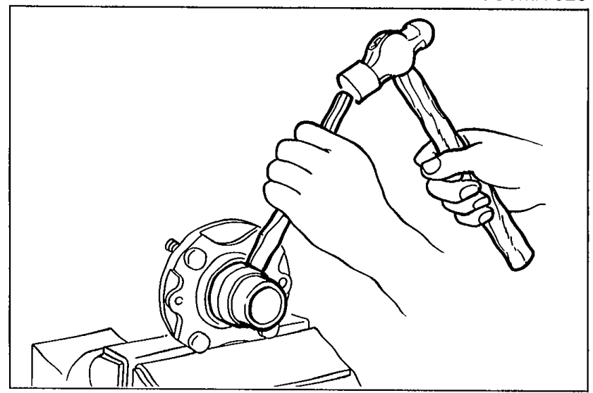 Photograph showing a chisel being used to move the bearing inner race away from the rear wheel hub assembly.