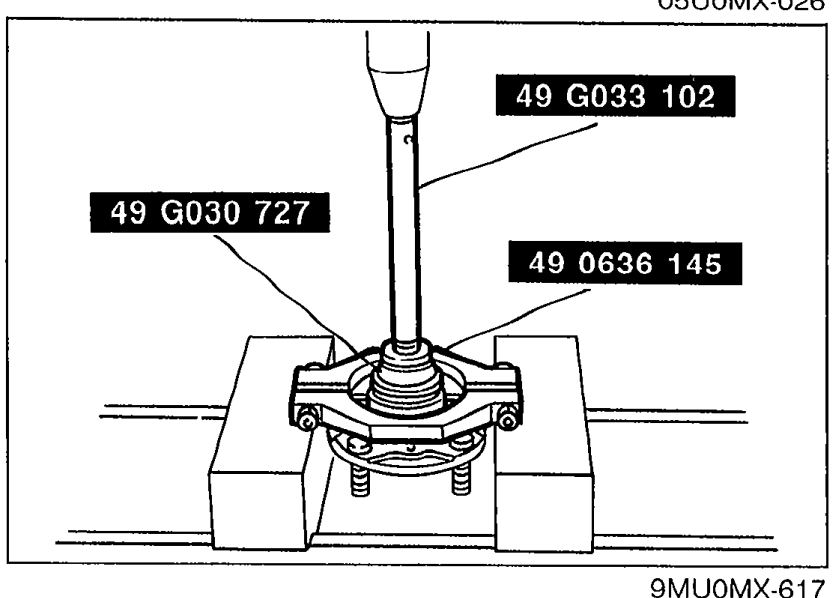 Photograph showing the bearing inner race being pressed off the wheel hub using SSTs '49 G033 102', '49 G030 727', and '49 0636 145'.