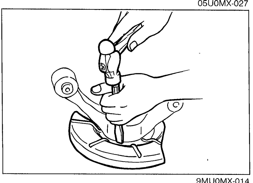 Photograph showing a chisel being used to remove the dust cover from the knuckle.