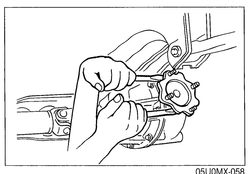 Hands using two pry bars to remove the output shaft from the differential, demonstrating the separation step.