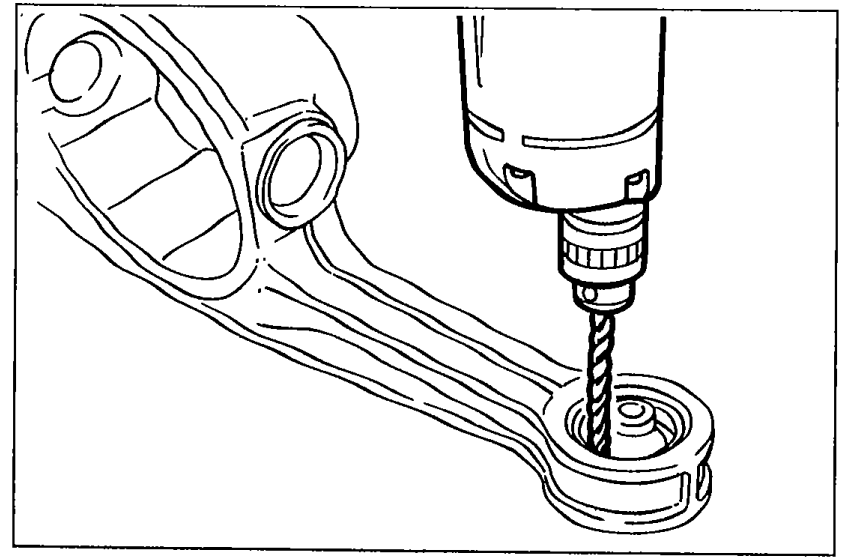 Illustration showing a drill being used to drill holes around the differential mounting rubber.