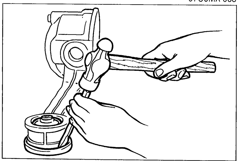 Illustration showing the edge of the differential mounting rubber being hit with a tool to remove it.