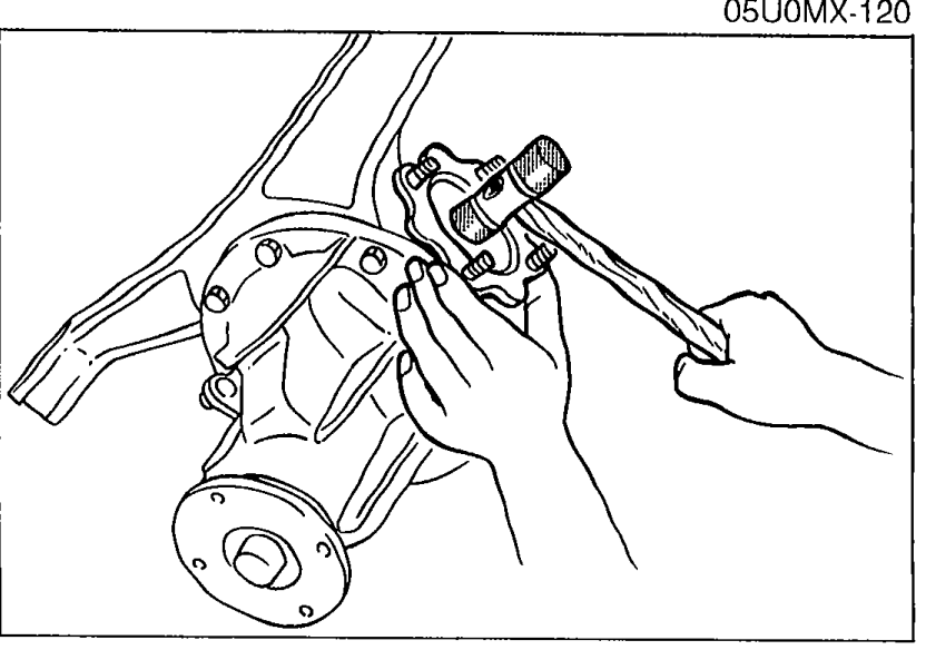 Photo showing a plastic hammer being used to tap the output shaft into the side gear of the differential.