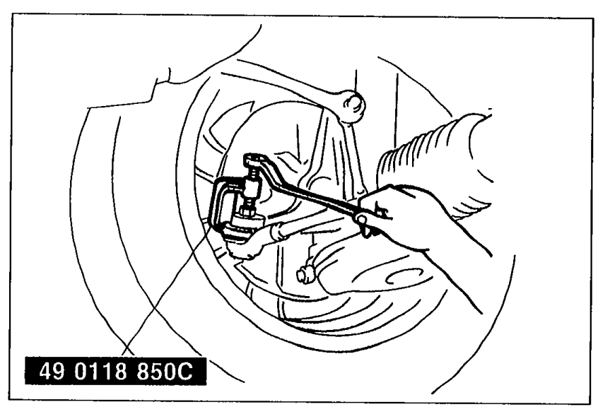 Mechanic using SST 49 0118 850C to separate the tie-rod end stud from the steering knuckle. The SST is clamped around the tie-rod end joint.