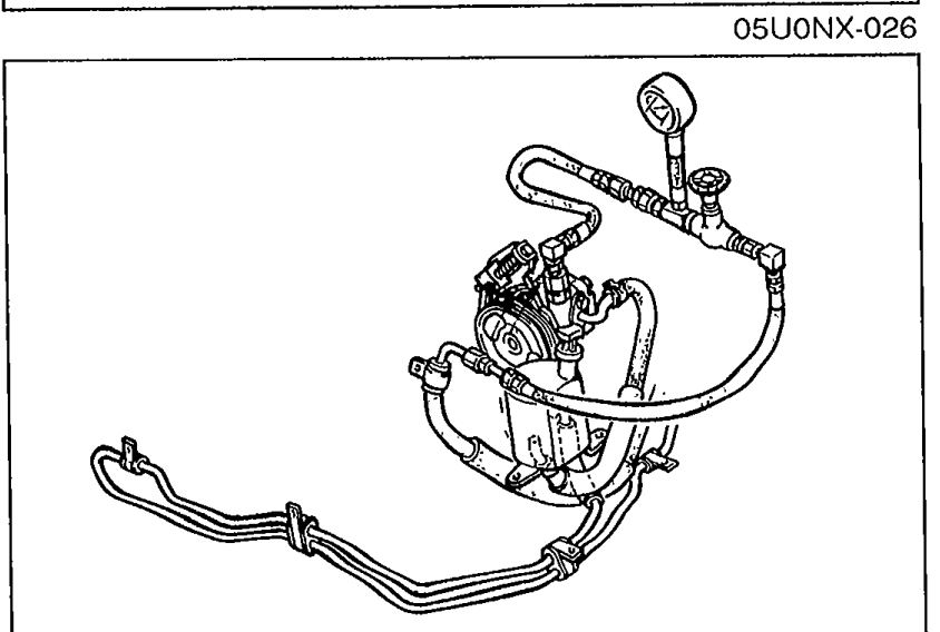 Engine bay view showing the oil pump area with high-pressure hose connection point. The hose routing is visible.
