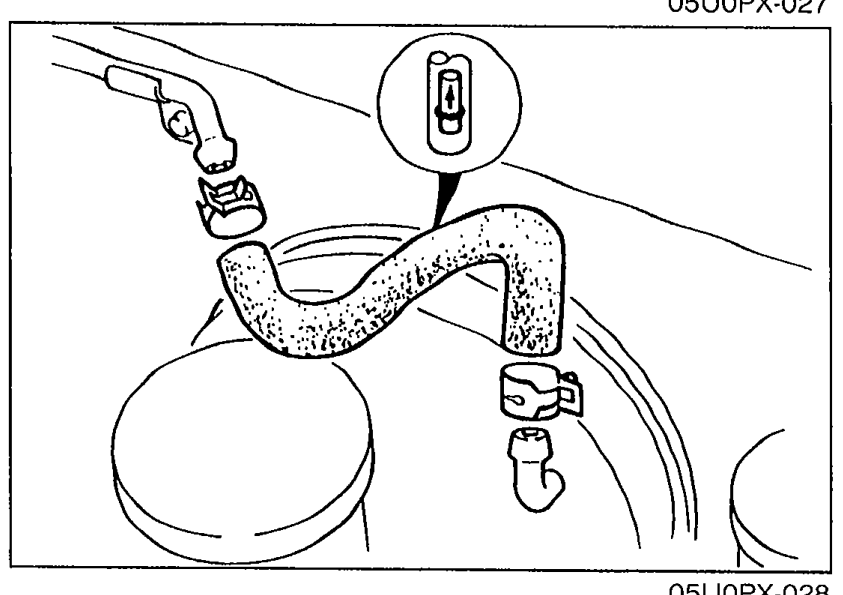 Vacuum hose with check valve. Hand applies suction/pressure to the disconnected end of the hose from the engine side; an arrow on the hose indicates installation direction.