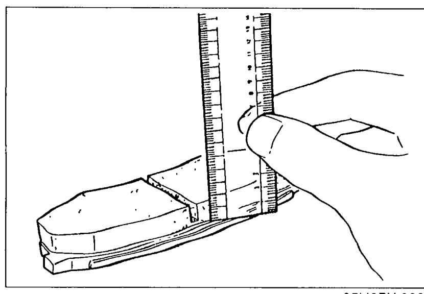 Illustration of measuring disc pad lining thickness with a vernier/scale gauge held against the disc-pad surface.